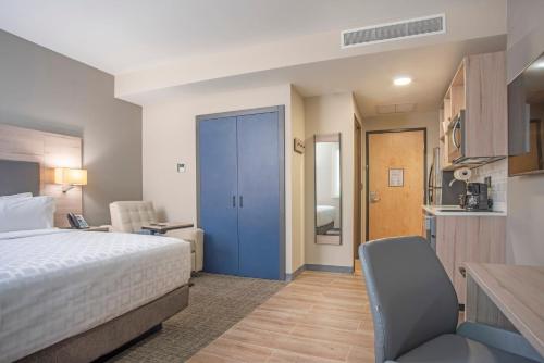 une chambre d'hôtel avec un lit et une cuisine dans l'établissement Candlewood Suites - Guadalajara Galerias by IHG, à Guadalajara