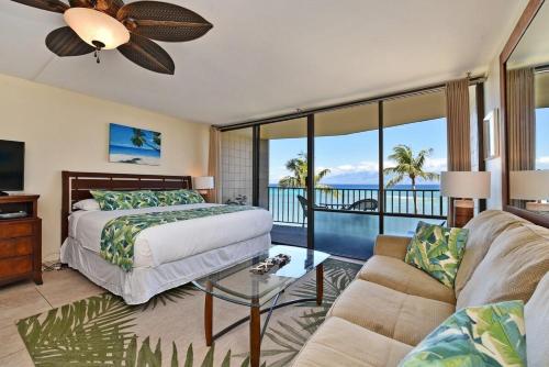 a bedroom with a bed and a couch at Valley Isle 407 · VI 407 BeachFront Studio w Pool in Kahana