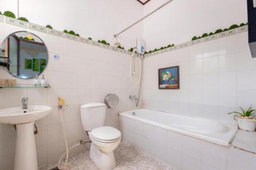 a white bathroom with a toilet and a sink at Biệt thự hồ bơi cho du khách bãi sau in Vung Tau