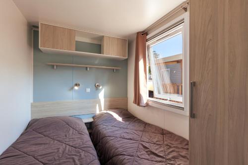 een slaapkamer met een bed en een raam bij Lou Soleil 80 in Carry-le-Rouet