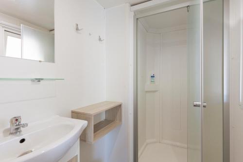 een witte badkamer met een wastafel en een douche bij Lou Soleil 80 in Carry-le-Rouet