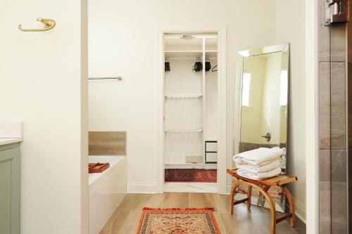 a bathroom with a mirror and a table with towels at New home with all the modern comforts 