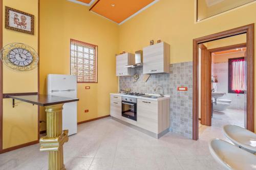 クアルトゥ・サンテーレナにあるVilla Angelaの黄色の壁と白の家電製品が備わるキッチン