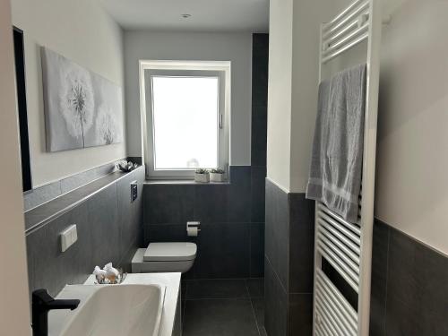 a bathroom with a white sink and a toilet at Stadtquartier Ahaus in Ahaus