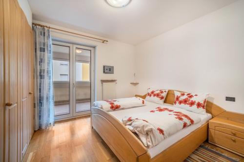 a bedroom with a bed with red flowers on it at Appartement Laurin in Merano