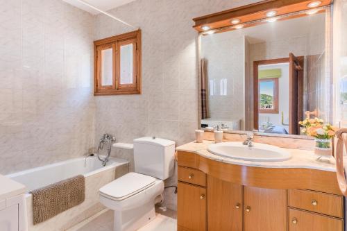 a bathroom with a toilet and a sink and a bath tub at Bellavista Port de Soller in Port de Soller