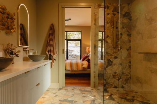 Un baño con ducha a ras de suelo y lavabo. en Parachilna at Boardwalk Villas, en Metung