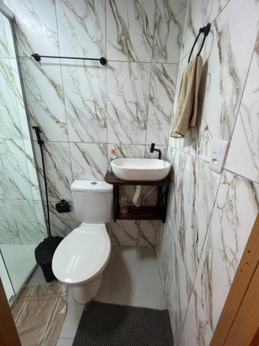 a bathroom with a white toilet and a sink at Casa completa no centro de Belém in Belém