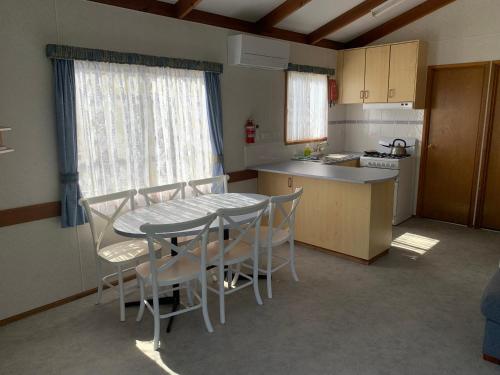 a kitchen with a table and chairs in a room at Beach Park Phillip Island - Cabins in Cowes