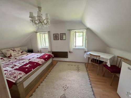 a bedroom with a bed and a table and a chandelier at Ferienhaus Maierhofer in Fischbach