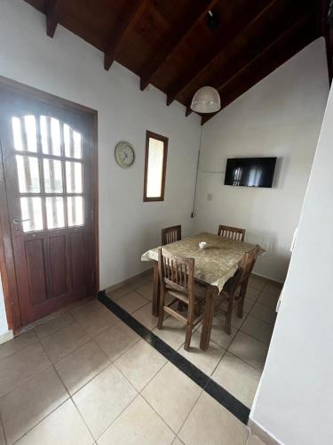 a dining room with a table and chairs and a door at Tu lugar en Santa Clara in Santa Clara del Mar