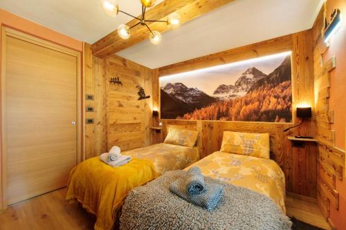 a bedroom with two beds and a painting on the wall at Le rêve d'Emilie - Family house in Valtournenche