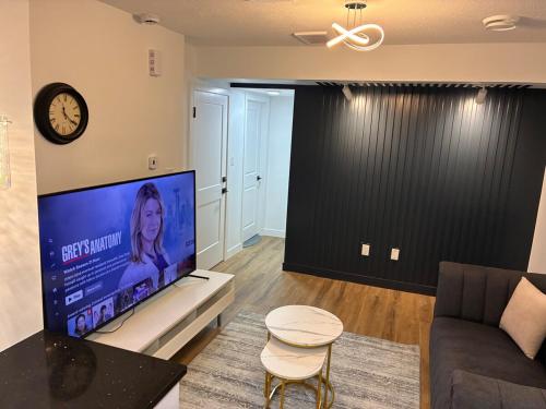 a living room with a couch and a large screen tv at Home away from Home in Edmonton