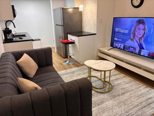 a living room with a couch and a flat screen tv at Home away from Home in Edmonton