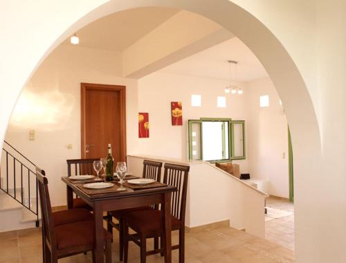 a dining room with a table and chairs and an archway at Villa Alexander in Gennadi