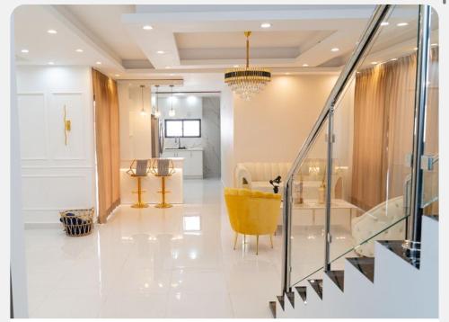 Una sala de estar con una silla amarilla y una escalera. en New family villa with a private pool, en Punta Cana