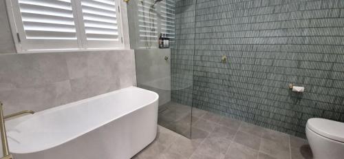 サンクチュアリ・ポイントにあるGreville Getaway - Absolute Waterfrontのバスタブとトイレ付きのバスルーム