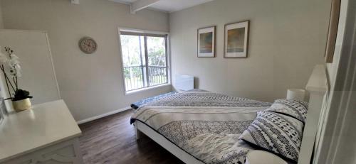 サンクチュアリ・ポイントにあるGreville Getaway - Absolute Waterfrontのベッドと窓のある白い寝室