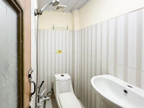 une salle de bains avec lavabo, baignoire et toilettes dans l'établissement Huiz de Rico Guesthouse Syariah near Ambarrukmo Area, à Demangan