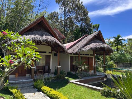 a small house with a thatched roof at Leuser Inn & Jungle Trekking in Bukit Lawang