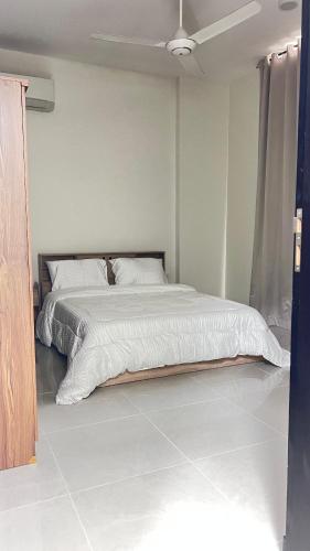 a bedroom with a bed with white sheets and a ceiling at مسقط العامرات in ‘Udhaybah