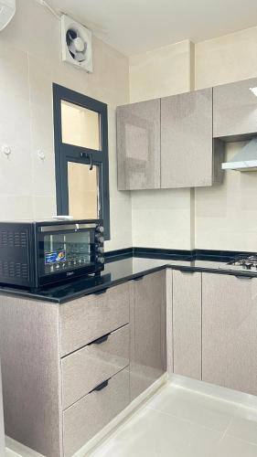 a kitchen with a microwave on top of a counter at مسقط العامرات in ‘Udhaybah