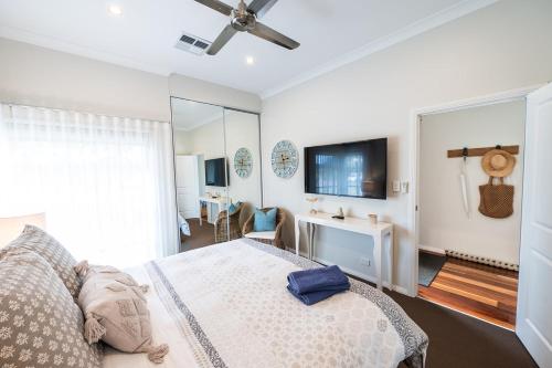a bedroom with a bed and a flat screen tv at The Lake House - Spacious Group Haven by the Bay in Victor Harbor