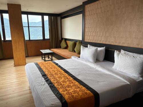una habitación de hotel con una cama grande y un sofá en Hotel Mist Tree Mountain, en Gangtok