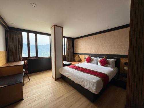 Un dormitorio con una cama grande en una habitación de hotel. en Hotel Mist Tree Mountain, en Gangtok
