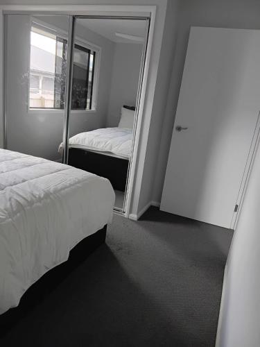 a bedroom with two beds and a mirror at Melaleuca Homestay in Bahrs Scrub