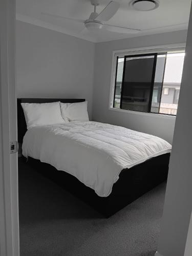 a bedroom with a large bed with a window at Melaleuca Homestay in Bahrs Scrub
