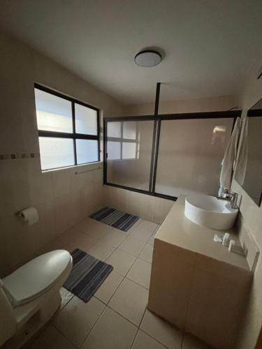 a bathroom with a white toilet and a sink at Casa Colibrí Querétaro in Querétaro