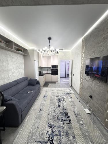 a living room with a couch and a tv at Элеганс в Континенталь in Bishkek