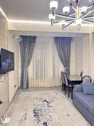 a living room with a blue couch and a table at Элеганс в Континенталь in Bishkek