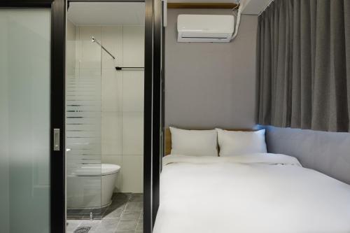 Unit M Hostel في سول: غرفة نوم صغيرة مع سرير ودش