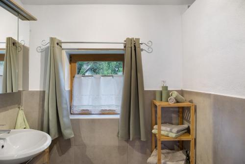 ein Badezimmer mit Waschbecken und Fenster in der Unterkunft Ferienwohnung Wankblick in Farchant