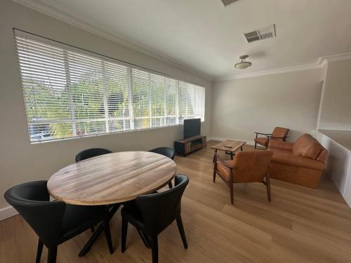 un salon avec une table, des chaises et un canapé dans l'établissement Riverston Loft, à Rockhampton