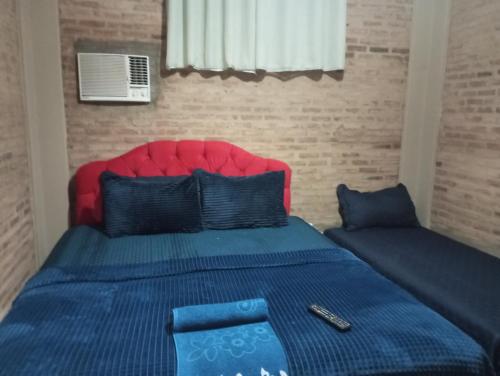 a bedroom with a bed with a red head board at Hotel Pousada Trevo in Barretos