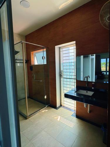 a bathroom with a glass shower and a sink at Entire Villa, Ferry Terminal Pickup & Breakfast in Batam Center