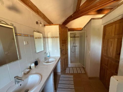 a bathroom with two sinks and a shower at Gîte avec piscine de 25 m et spa in Saint-Mathieu-de-Tréviers