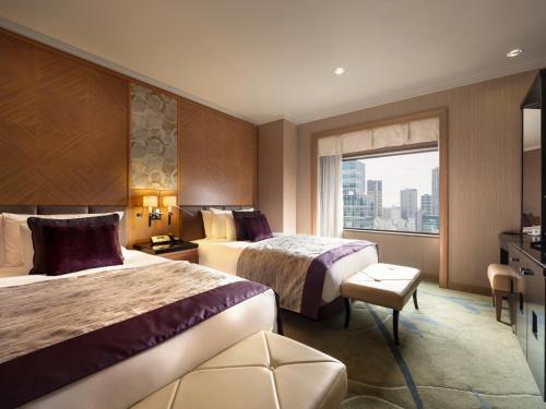 a hotel room with two beds and a window at Hotel Metropolitan Tokyo Ikebukuro in Tokyo