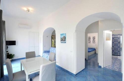 a dining room with a white table and a bedroom at Casa Emi in Amalfi