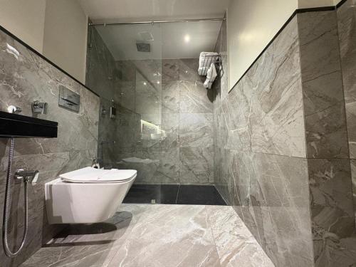 Un baño con inodoro blanco y ducha. en SandDune Luxury Suites, en Ernakulam