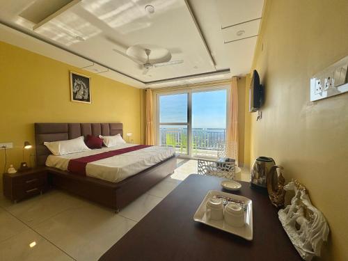 a bedroom with a bed and a large window at Serene Vista Dharamshala in Dharmsāla