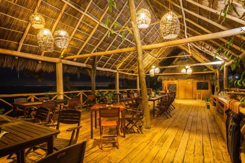 a restaurant with wooden tables and chairs and chandeliers at Xinalani Retreat Mexico in Qumiste