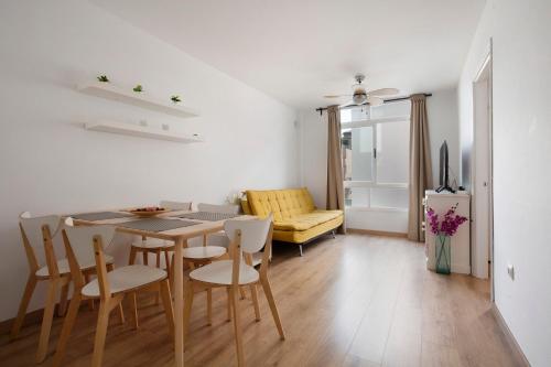 a dining room and living room with a table and chairs at Apartamento Playa Morro Jable 2c in Morro del Jable