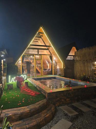 a house with a pool in the yard at night at Baku Garden Aframe - Bungalov in Baku