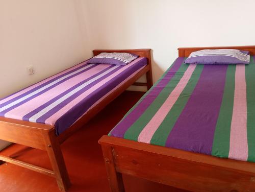 two beds sitting next to each other in a room at Freedom Lodge in Ella
