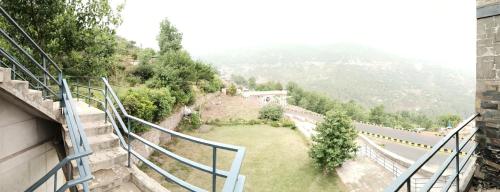 a view from a balcony of a building with a grass field at Luxe Villa in Murree