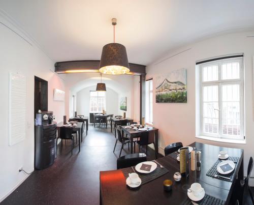 a dining room with tables and chairs and windows at Der Zauberlehrling in Stuttgart